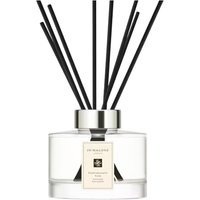 Jo Malone Pomegranate Noir diffuser with clear glass bottle, silver cap, and black reeds.