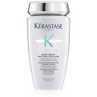 Kérastase Symbiose shampoo in a sleek white bottle with silver cap and teal accents.