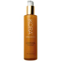 Kora Organics Turmeric Glow Foaming Cleanser, 150 ml, in a sleek amber bottle with a gold pump dispenser.
