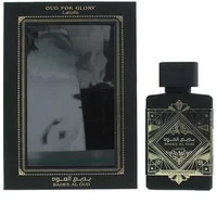 Black Lattafa Bade'e Al Oud perfume bottle with ornate gold design, next to matching black and gold box.
