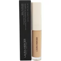 Laura Mercier concealer in beige tube with black cap, next to matching black box packaging.