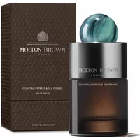 Molton Brown perfume bottle with teal cap, dark gradient glass, beside textured brown box with silver logo.