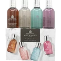 Molton Brown body care set with four 100ml bottles in brown, pink, blue, and purple, silver caps, on a marble box.