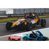 Black and orange race car on track, red Lamborghini, blue McLaren with open doors in foreground.