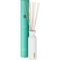 White Rituals Karma fragrance sticks in a sleek white vase with a turquoise cylindrical box.