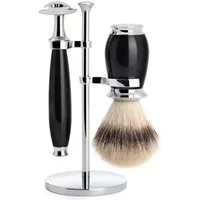 Black and chrome Mühle safety razor kit with stand, includes razor, brush with silver tip bristles, and sleek holder.
