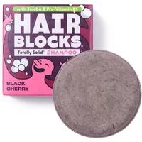 Black cherry solid shampoo bar with a round, textured surface next to a pink and black box labeled "Hair Blocks."