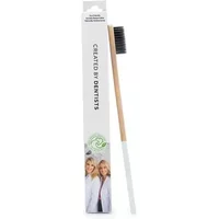 Bamboo toothbrush with white handle, black bristles, and packaging featuring dentists' image and eco-friendly logo.