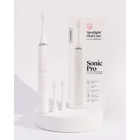 White Spotlight Oral Care Sonic Pro toothbrush with three brush heads and sleek charging base.