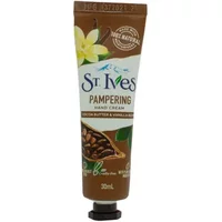 Brown tube of St. Ives Pampering Hand Cream with cocoa beans and vanilla flower design, 30ml size.