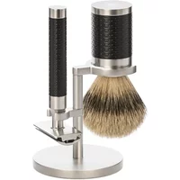 Stainless steel safety razor kit with textured black handles, shaving brush, and stand by Mühle.