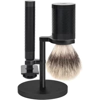 Stainless steel safety shaving kit with black textured handle, synthetic brush, and sleek stand by Mühle Rocca.