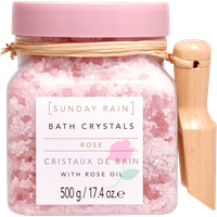 Pink jar of Sunday Rain Rose Bath Crystals with wooden scoop and rose oil label, 500g.