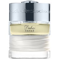 Clear glass bottle with silver cap, featuring "Dubai Bahar" text, and a white textured base, containing yellow perfume.