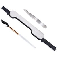 Tweezerman grooming set with silver tweezers, black and white brow brush, and dual-ended white brow razor.