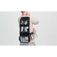 Black Victoria Green hanging wash bag with multiple compartments, clear pockets, and toiletries inside.