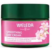 Weleda Smoothing Day Face Cream jar with pink label, green lid, featuring wild rose and white tea graphics, 40ml size.