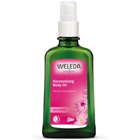 Green Weleda Wild Rose Body Oil bottle with white pump and pink label featuring floral design, 100ml size.