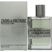 Clear glass bottle with silver cap, labeled "Zadig & Voltaire This Is Really Him!" next to matching silver box.