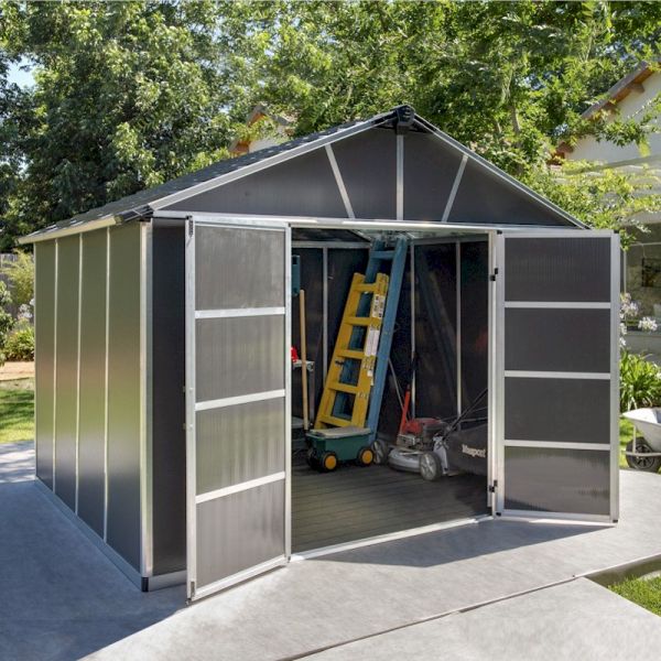 Dark grey plastic shed with a WPC floor, featuring double doors, a sloped roof, and a spacious interior visible with tools and equipment inside, set in a garden environment.