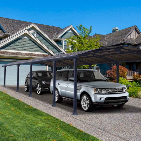 Grey metal carport measuring 12' x 35', featuring a sleek design with a curved roof, providing shelter for two vehicles in a residential driveway setting.