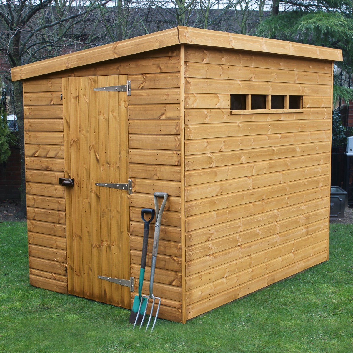 Traditional 12' x 6' wooden garden shed with a pent roof, featuring a natural wood finish, a single door with a latch, a small window, and gardening tools leaning against it.