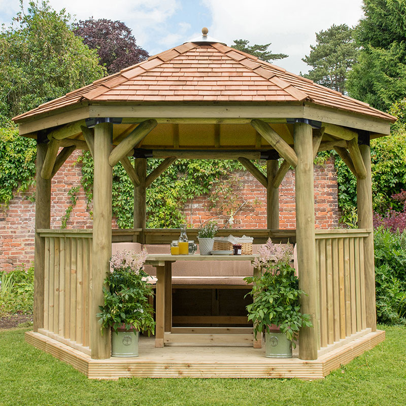 Luxury wooden gazebo featuring a New England cedar roof, spacious seating for up to 10, surrounded by potted plants, set in a lush garden.