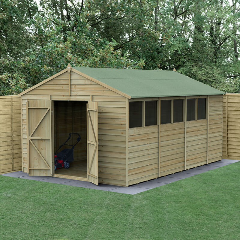A wooden apex shed with a green felt roof, featuring double doors, large windows, and pressure-treated timber, set in a grassy area surrounded by wooden fencing.