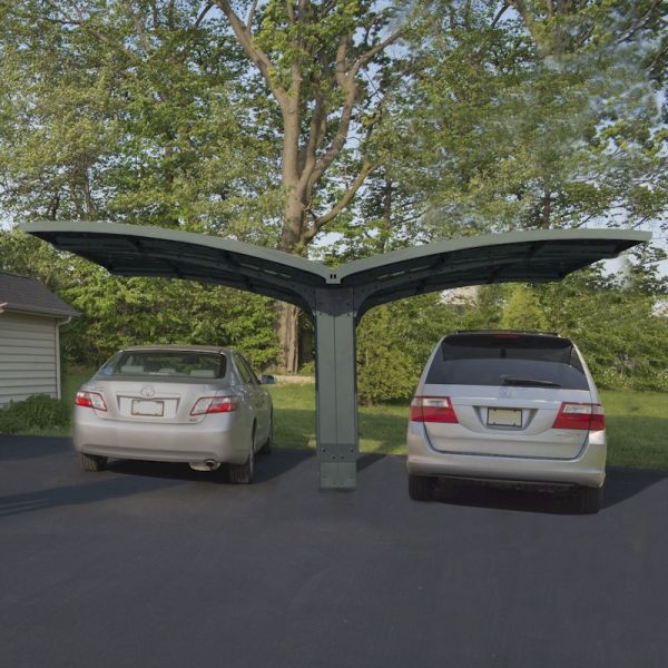 Grey metal double carport with a modern design, featuring a curved roof, accommodating two vehicles, set in a landscaped outdoor area with trees.