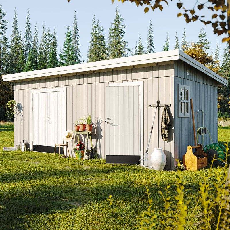 A spacious, light gray wooden shed with a flat roof, featuring two doors, large windows, and surrounded by greenery, showcasing gardening tools and decorative plants.
