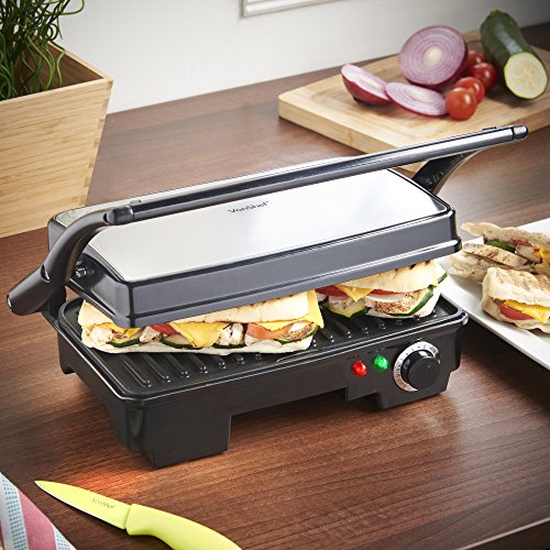 Black VonShef 2 Slice Sandwich Grill with a stainless steel top, grill plates, adjustable temperature control, and indicator lights, set on a wooden countertop with fresh ingredients nearby.