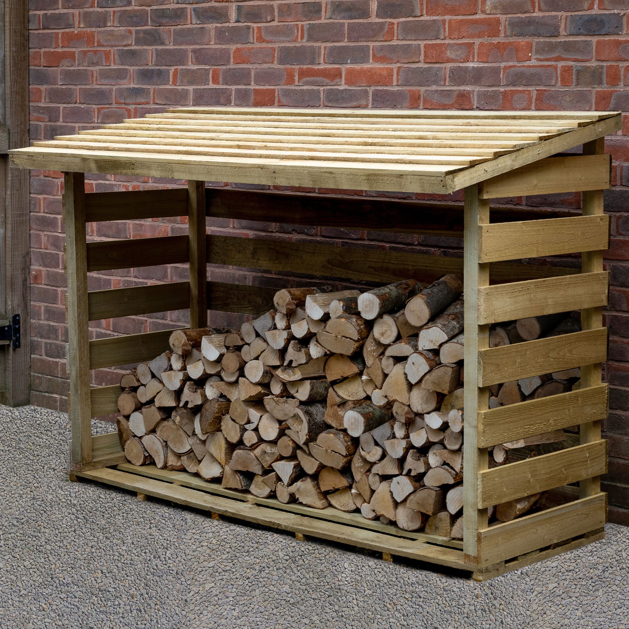 Large wooden log store in natural finish, measuring 5'11" x 2'8", featuring a slatted roof and open sides, filled with neatly stacked logs against a brick wall background.