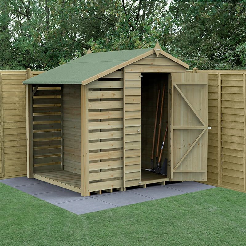 Wooden apex shed with a green felt roof, featuring untreated timber slats, a log store, and double doors, set on a paved area surrounded by wooden fencing and grass.
