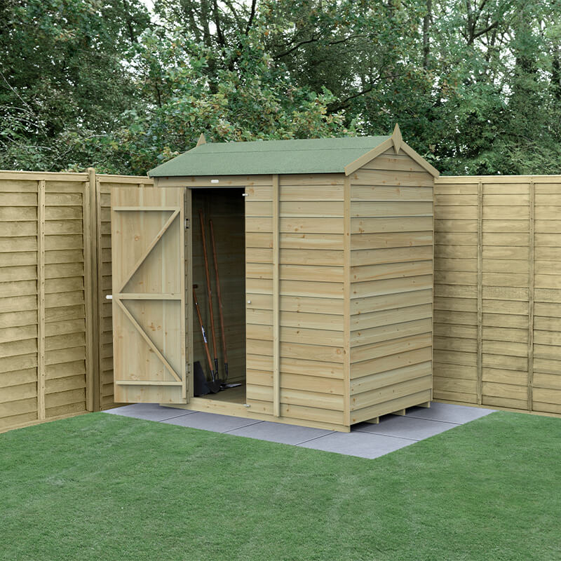 A wooden shed with a reverse apex roof, pressure-treated, featuring a natural wood finish, double doors, and standing on a paved base, surrounded by wooden fencing and grass.