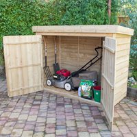 Large wooden garden storage shed in natural wood finish, featuring double doors, storing a lawn mower and gardening tools, set on a paved outdoor area with greenery in the background.