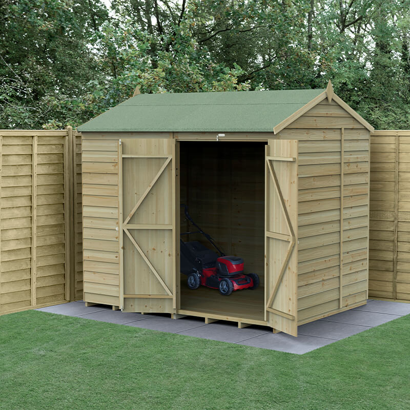 Wooden shed with a reverse apex roof, pressure-treated timber, double doors, and no windows, set on a paved area with a lawn, featuring a red lawnmower inside.