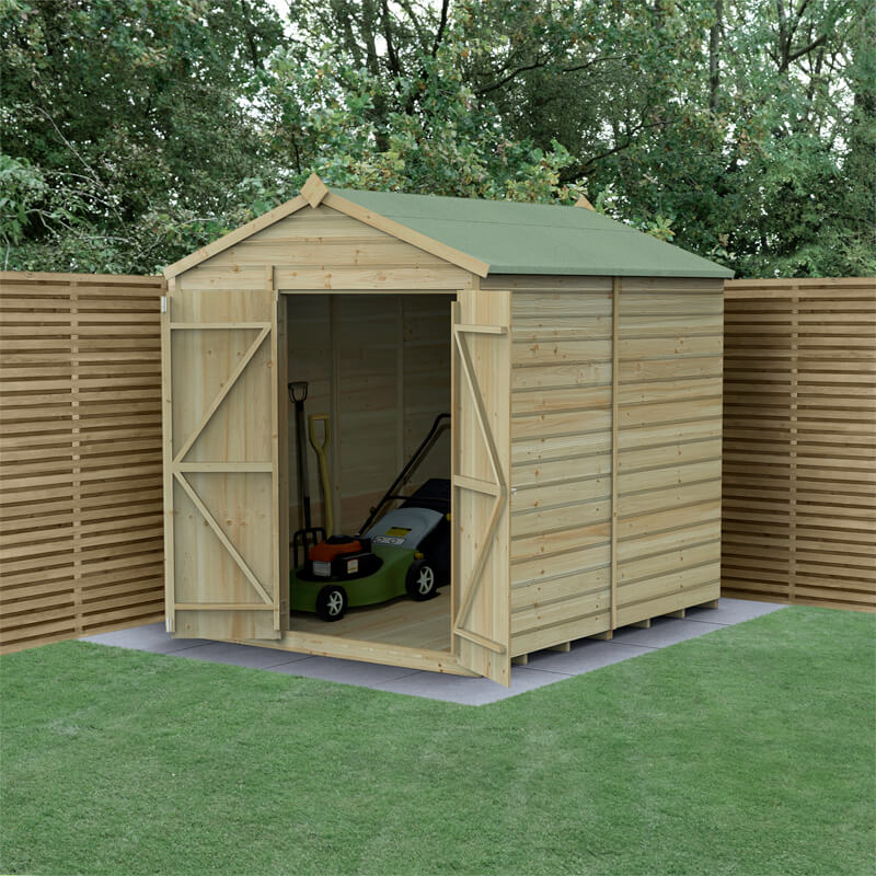 Wooden shed with a double door apex design, featuring shiplap pressure-treated timber, a green roof, and a spacious interior, set against a backdrop of wooden fencing and grass.