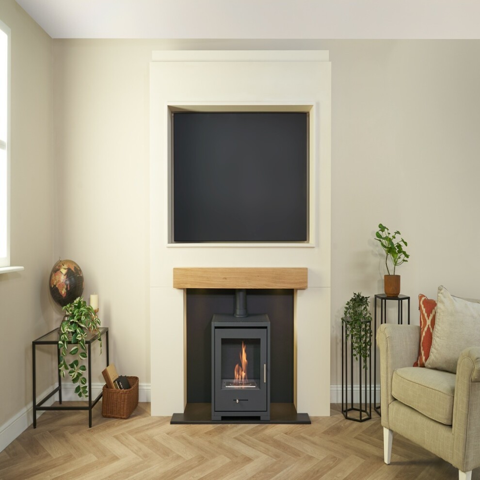 Acantha Pre-Built Stove Media Wall features a sleek design with a TV recess, a natural wood mantel, a black bio-ethanol stove, and decorative plants in a modern living space.