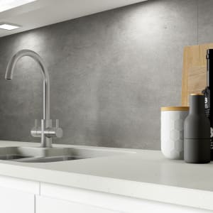 Concrete-effect splashback in grey, measuring 900 x 25 x 800mm, complements a modern kitchen with a sleek faucet, wooden cutting board, and stylish black and white containers.