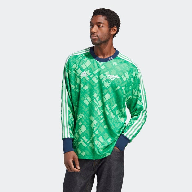 Green Arsenal Icon Goalkeeper Jersey featuring a geometric pattern, long sleeves, blue cuffs, and white Adidas stripes on the shoulders.