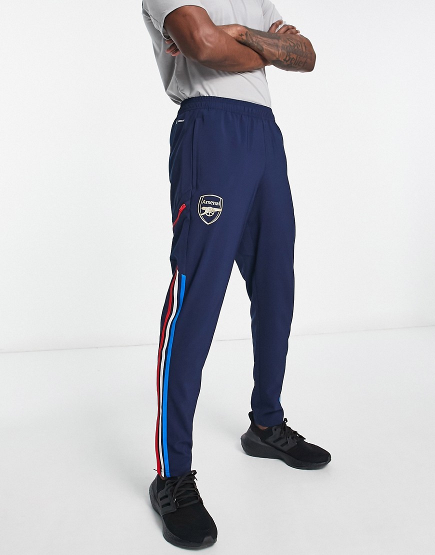Navy-blue Adidas joggers featuring the Arsenal FC logo, with red and light blue stripes down the sides and an elastic waistband for comfort.