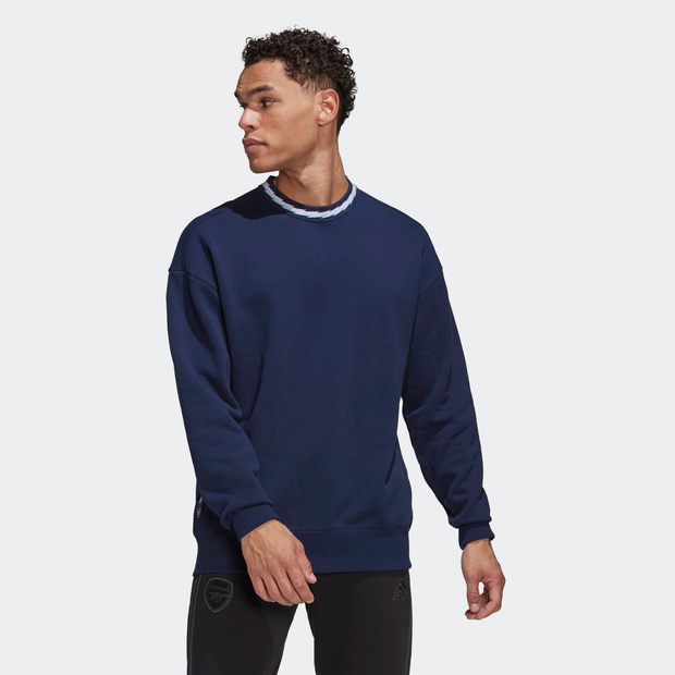 Navy blue crewneck sweatshirt made of soft material, featuring a ribbed neckline and subtle Arsenal branding on the side, ideal for casual wear.