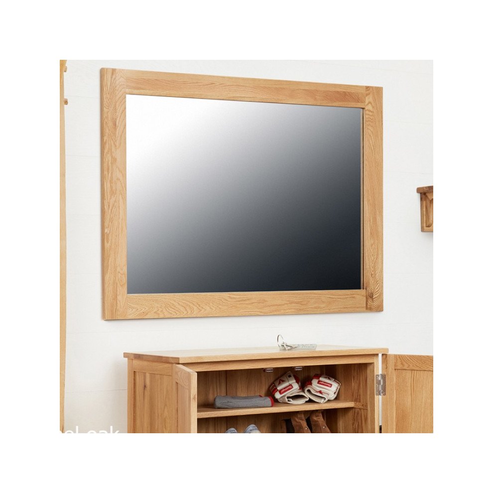 Medium-sized wall mirror with a brown oak frame, featuring a sleek design and a reflective surface, mounted above a wooden storage unit.