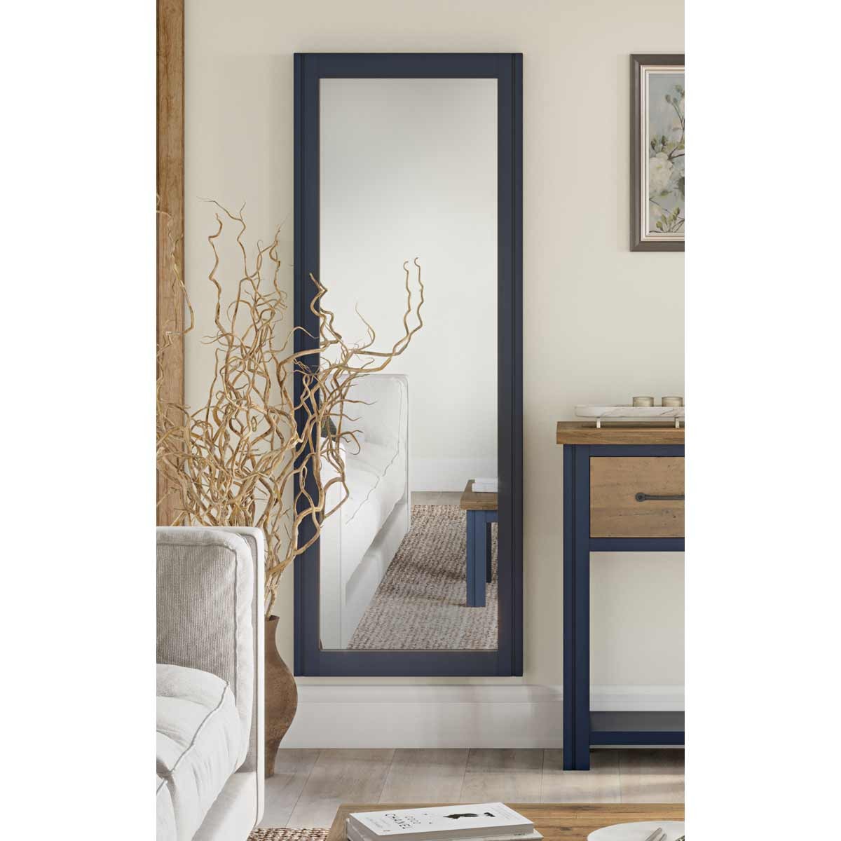 Extra long wall mirror in blue frame, designed for landscape and portrait hanging, reflecting a cozy interior with a light-colored sofa and wooden furniture.