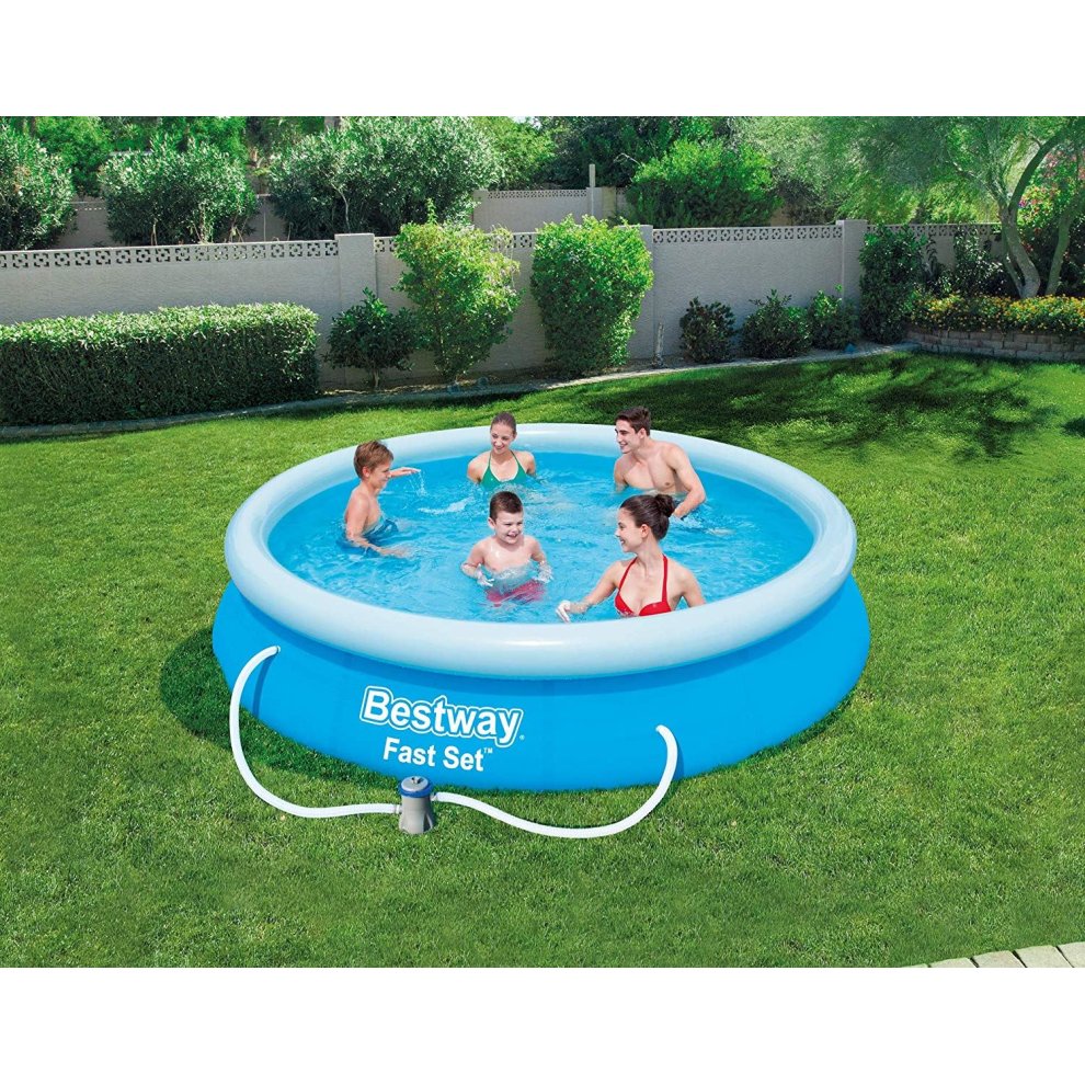 Round, inflatable blue pool set measuring 12 feet by 30 inches, featuring children playing in the water, surrounded by green grass and trees.