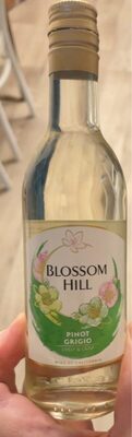 Clear glass bottle of Blossom Hill Pinot Grigio, 187 ml, featuring a white label with green floral accents and gold cap.