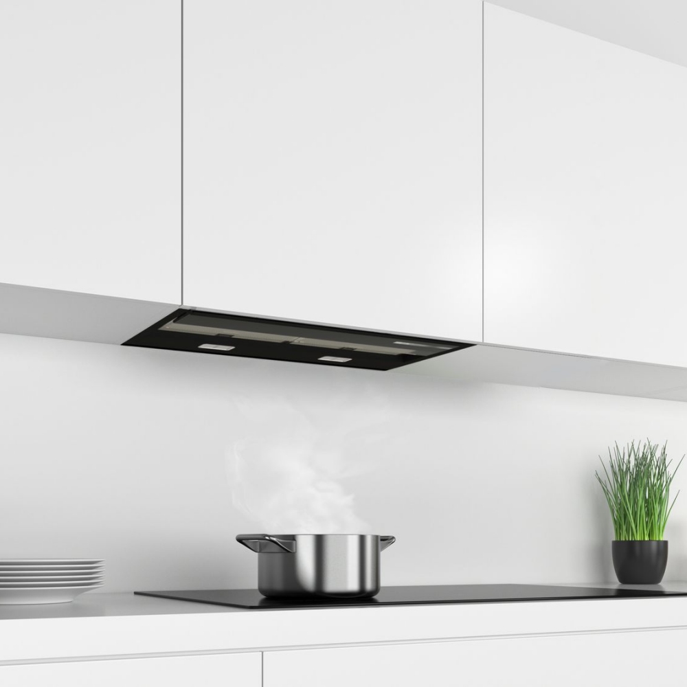 Bosch DBB67AM60B Series6 60cm flush integrated hood in black glass, mounted under white cabinets, with a stainless steel pot releasing steam on a sleek countertop.