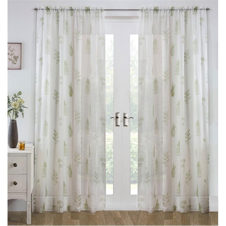 Sheer white voile panel with an all-over green leaf pattern, designed by Tyrone Textiles, hanging elegantly over a set of double doors.