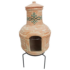 Small brown terracotta clay chiminea with a BBQ grill, featuring a decorative design and a large opening, supported by a black metal stand.