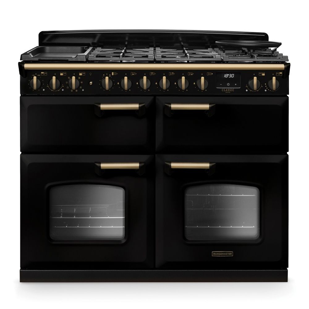 Classic Deluxe 110cm dual fuel range cooker in black with antique brass accents, featuring four gas burners, a griddle, and two large glass-fronted ovens.